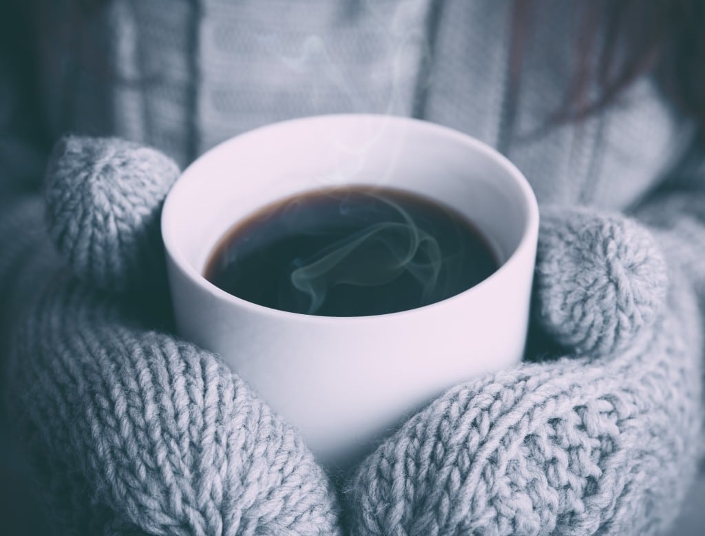 quelqu'un tenant une tasse de thé chaud