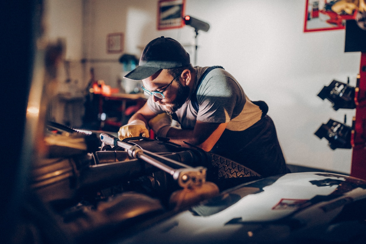 Repair man working in garage on repair of old timer