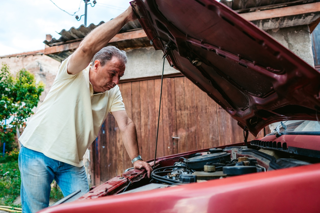 Senior man repairing car